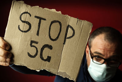 Close-up portrait of man holding text