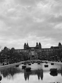 Arch bridge over river against buildings in city