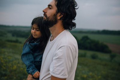 Father carrying child outdoors on hike