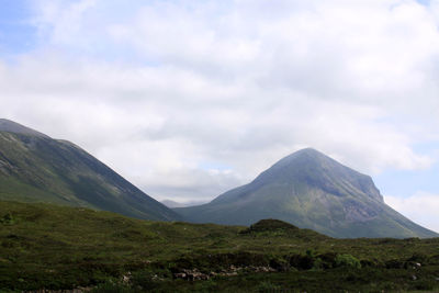 Scenic view of mountains against cloudy sky