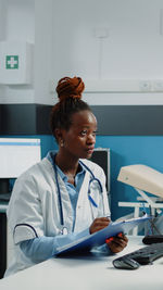 Female doctor writing prescription at clinic