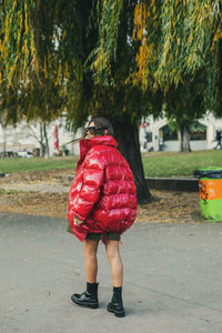 Rear view of woman wearing warm clothing while standing on footpath at park