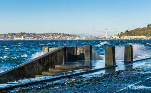 Waves crash onto the shore at alki beach in west seattle, washington.