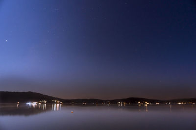 Scenic view of lake against sky at night