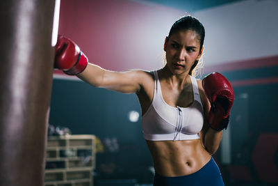 Concentrated young asian training boxing in the gym