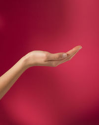 Close-up of woman hand with red colored background