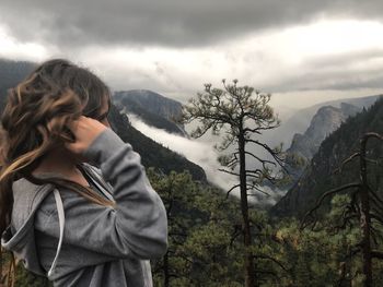 Young woman against mountains and sky