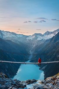 Rear view of person on snowcapped mountain against sky