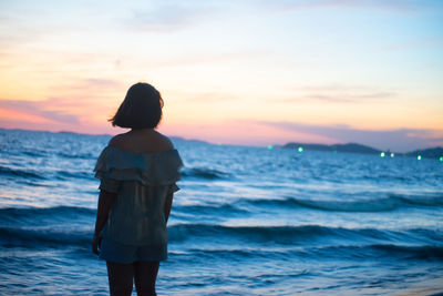 Rear view of woman standing on beach