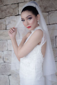 Portrait of bride in front of brick wall