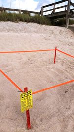 High angle view of warning sign by turtle nest at beach