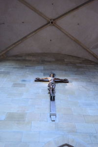 Young woman with statue on wall