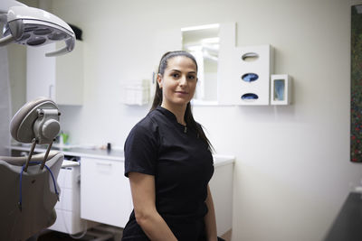 Female dentist standing in office