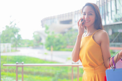 Smiling young woman using mobile phone