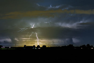 Panoramic view of silhouette lightning against sky at night