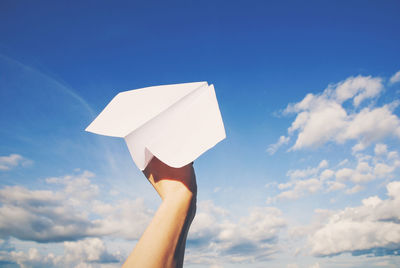 Paper plane in hand ready to fly
