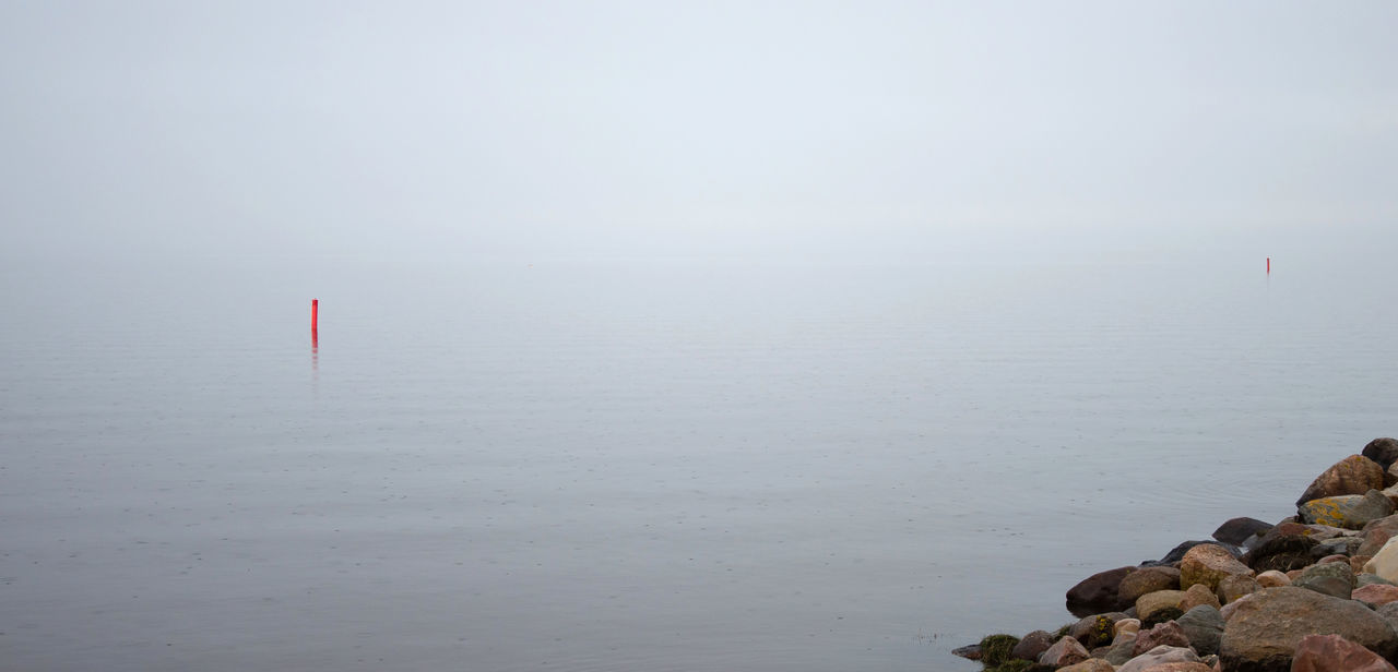 ROCKS IN SEA AGAINST SKY