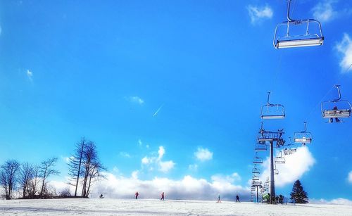 Low angle view of ski lift against sky during winter