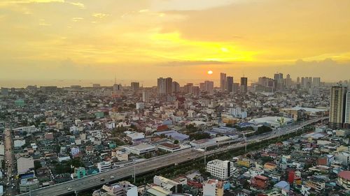 Aerial view of cityscape against sky during sunset