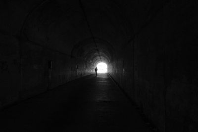 Silhouette person in dark tunnel