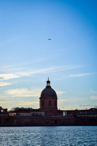 View of building by canal against sky