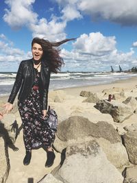 Full length of smiling young woman on beach