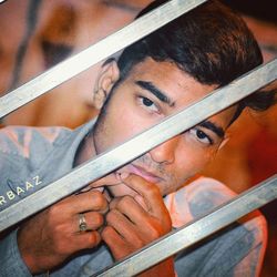 Close-up portrait of young man holding camera