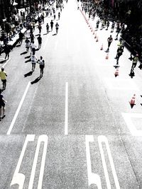 High angle view of people running in marathon on city street