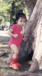 Cute girl playing with tree trunk