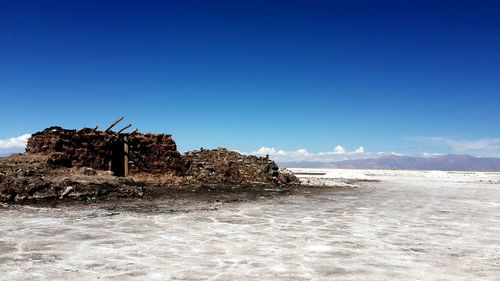 Scenic view of beach against blue sky