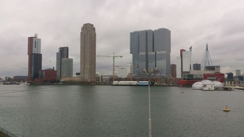 Buildings in city against cloudy sky