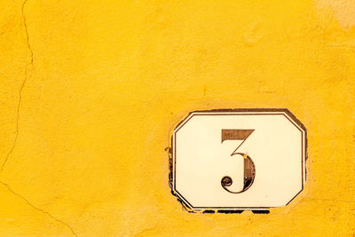 Close-up of number 3 on yellow wall