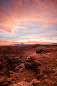 Scenic view of rocky shore against sky during sunset