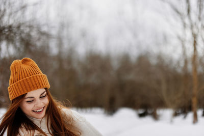 Portrait of smiling young woman standing on snow