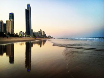 Scenic view of sea and buildings against sky during sunset