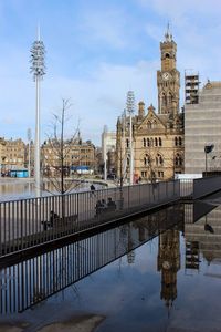 Reflection of clock tower in rain puddle on footpath