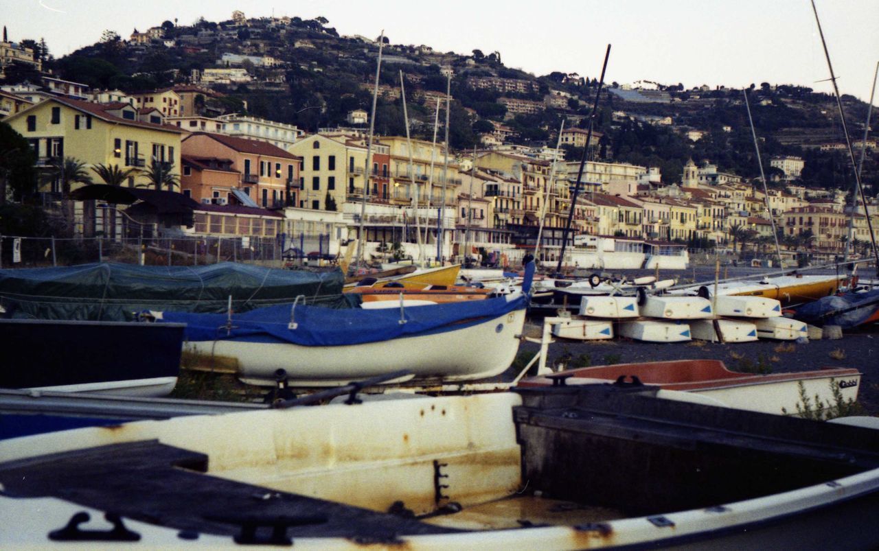 BOATS MOORED AT HARBOR BY SEA