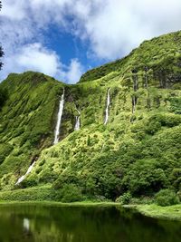 Low angle view of green mountains against sky