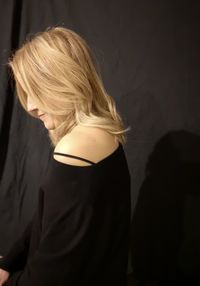 Side view of woman against black background