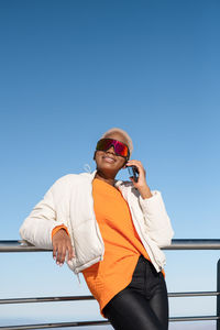 A young african american woman wearing sunglasses having fun in the snow on a winter day