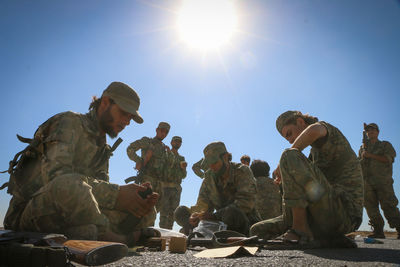 Panoramic view of people sitting against clear blue sky