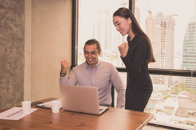 Young colleagues working at table in office