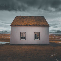 House on field against sky during winter