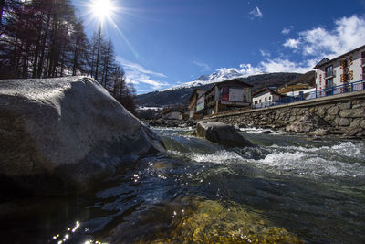 River flowing amidst buildings against sky