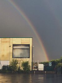 Scenic view of rainbow over river in city