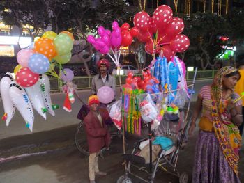 People with colorful balloons in city