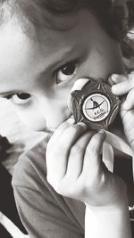 Close-up of boy holding clock