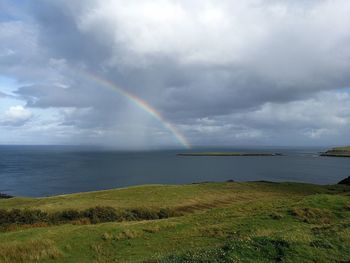 Scenic view of rainbow over sea against sky