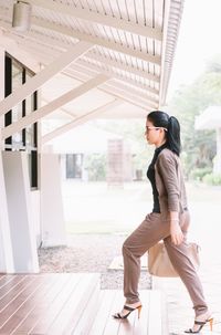 Side view of businesswoman walking on steps at office