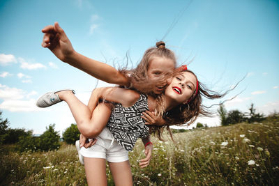 Girls sisters have fun playing in the meadow